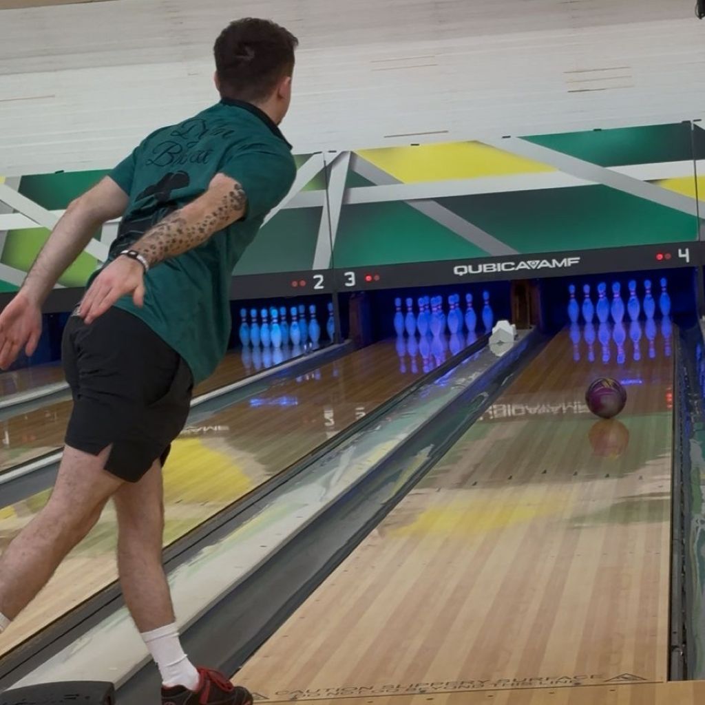 Back view of competitive bowler Dylan Blessett wearing his AV Edge Legend White/Black frequency wristband during a 10-pin bowling delivery, demonstrating how the HEF Technology might support biomechanical coordination, mental focus, and balance for improved release consistency and peak athletic performance.