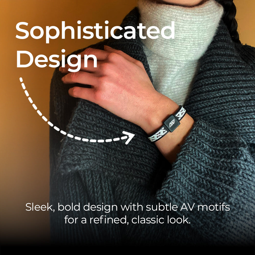 A close-up of a person wearing a discreet AV Edge Legend frequency bracelet over a grey knitted sweater, showcasing the refined, sophisticated design that may support balance, sleep, and natural EMF protection for those seeking style and wellness.